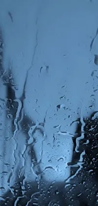 This phone live wallpaper depicts a close-up of a rain-streaked window, featuring a captivating blue-tinted painting of a lyrical abstraction style