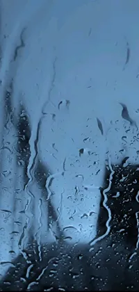 This live wallpaper features an up-close shot of raindrops on a window, styled in cool blue hues