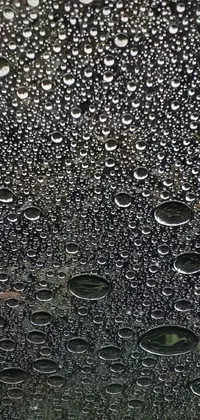 This phone live wallpaper features a stunning image of raindrops on a car windshield