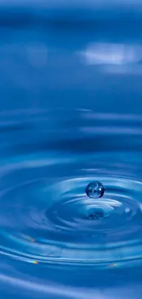 This phone live wallpaper features a serene water drop in a body of water, set against a calming blue background