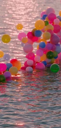 This lively phone live wallpaper features a group of colorful balloons hovering over a serene body of water