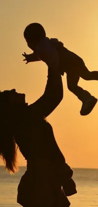 Looking for a captivating phone live wallpaper that showcases the beauty of motherhood and nature? Look no further than this stunning image from Pexels! The enhanced photo features an unnamed woman holding a baby up in the air against a picturesque sunset backdrop