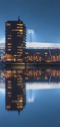 This phone live wallpaper showcases a striking image of a tall building next to a body of water in a stadium-like setting
