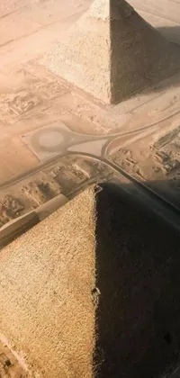 This mesmerizing phone live wallpaper presents the hyperrealistic aerial view of three pyramids rising from the desert sand, alongside a bustling city and a morning atmosphere