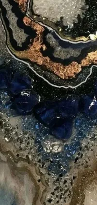 This phone live wallpaper features a stunning close-up view of a beautiful piece of artwork centered around a mix of sapphire, stone, glass, and gold accents