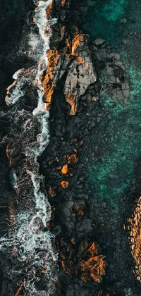 This phone live wallpaper showcases an aerial view of a striking body of water with orange rocks in the foreground