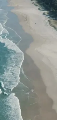 Looking for a phone live wallpaper that will take your breath away? Look no further than this stunning aerial shot from the South African coast! Featuring a vast body of water next to a sandy beach, this image captures the intricate textures of sand and water with breathtaking clarity