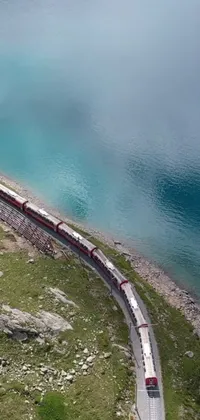 Experience the beauty of the Swiss Alps with this stunning live wallpaper of a long train on a steel track near a peaceful body of water