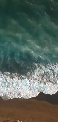 Ride the waves with this phone live wallpaper featuring a surfer on a sandy beach