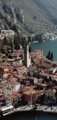 Looking for a peaceful and serene live wallpaper for your phone? This beautiful aerial view features a charming town nestled by the tranquil waters of a lake