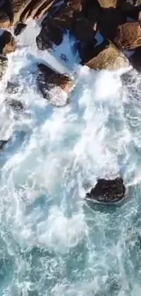 This mobile live wallpaper features a breathtaking body of water surrounded by rugged rocks that's sure to captivate users