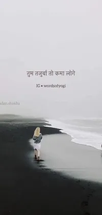 This phone live wallpaper depicts a beautiful woman standing on a black sand beach, facing the ocean