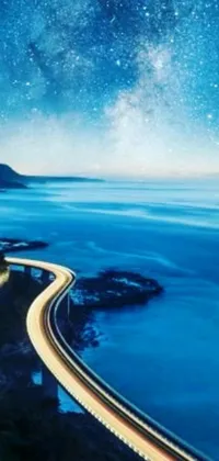 This stunning live phone wallpaper features a winding road along a mountain on the ocean, a clear Australian winter night, and fantastic realism