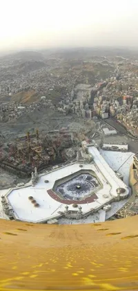 This phone live wallpaper captures a stunning aerial view of a popular city from a plane, with the emptiness of the hurufiyya, ka'bah or kabah, in sharp contrast