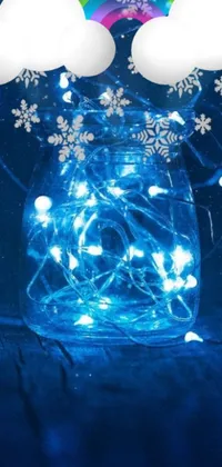 This phone live wallpaper features a glass jar filled with fairy lights and snowflakes in blue color scheme