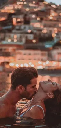 This live wallpaper showcases a peaceful body of water with a beautiful couple engaged in a romantic kiss