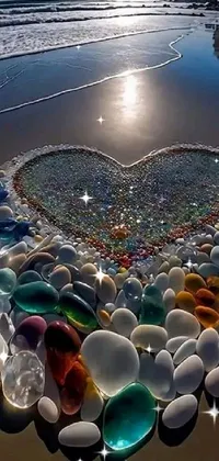 This stunning 4K live wallpaper features a heart made entirely of sea glass arranged in a beautiful mosaic pattern on a serene beach