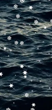 Enjoy a stunning live wallpaper featuring snowflakes floating above a calm body of water, completed by an oceanic pattern and a beautiful night sky
