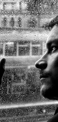 Get lost in this black and white phone live wallpaper as you gaze at an artistic portrait of a man standing by a window the day after it was raining