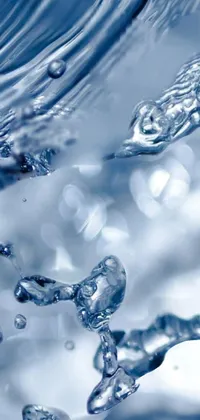 This stunning live wallpaper features a close-up of crystal clear water pouring from a faucet, surrounded by glinting particles of ice