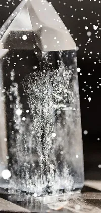 This live phone wallpaper features a crystal atop a table with an etching