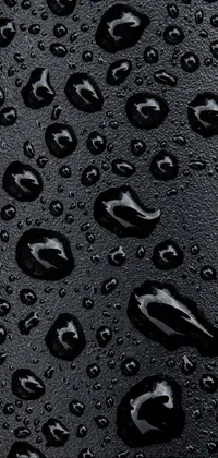 This phone live wallpaper boasts a stunning close-up of water droplets on a black surface