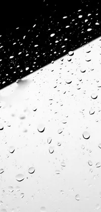 Looking for a stylish phone wallpaper? Look no further! This black and white live wallpaper features raindrops on a window, inspired by Lucio Fontana's minimalistic style