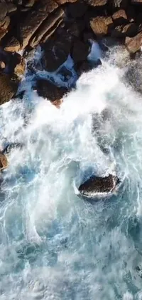 Surfer live wallpaper featuring a muscular man skillfully riding a towering wave while rocks fall from the cliffs behind