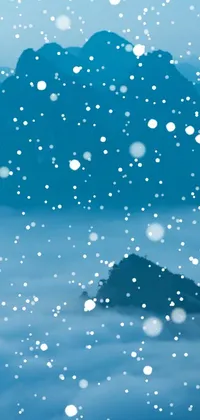 This live wallpaper portrays a snow-covered mountain with snowflakes falling against a calming blue background