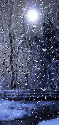 This live wallpaper for your phone features a realistic digital rendering of a snow-covered window next to a street light in the midst of a light rain