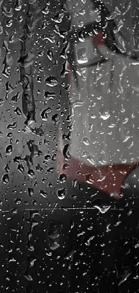 This phone live wallpaper showcases a magnificent black and white image of an individual standing in the rain