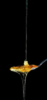 Get mesmerized by this stunning live wallpaper featuring a macro photograph of honey being slowly dripped from a spoon