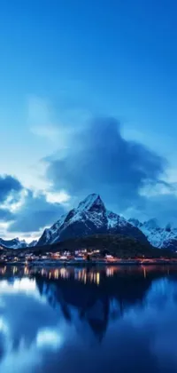 This stunning live wallpaper features a serene blue hour scene of a picturesque mountain range in the background and a large body of water in the foreground