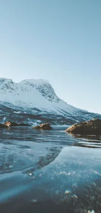 This phone live wallpaper showcases a serene body of water with a towering mountain in the background
