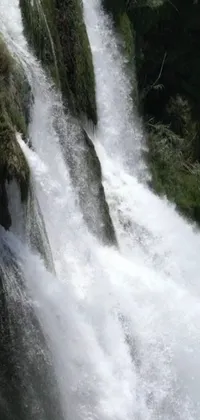 This mesmerizing live wallpaper depicts a stunning waterfall as water cascades down its serene pools