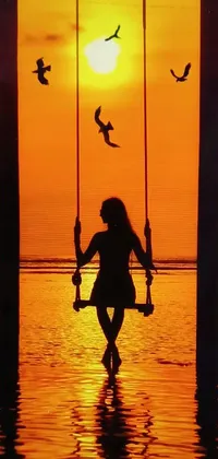 This phone live wallpaper features a serene scene of a person enjoying a swing in the calm waters of Bali
