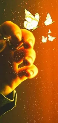 This phone live wallpaper features a stunning image of a person holding a bunch of butterflies in their hand