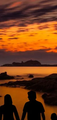 Looking for a visually stunning live wallpaper for your phone? Check out this dark orange night sky Live wallpaper with rocky foreground and beautiful islands in the distance