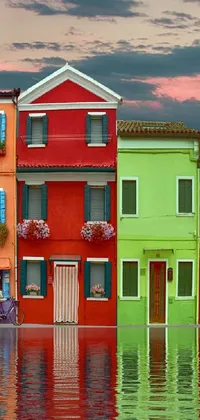 This phone live wallpaper features a beautiful row of colorful houses next to a body of water, depicted with vibrant and bold colored walls
