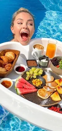 This beautifully designed live phone wallpaper features a woman gracefully holding a tray of delicious food while floating in a crystal clear pool