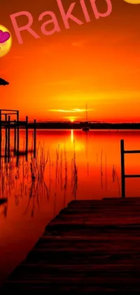Get ready to transform your mobile device's screen with this impressive phone live wallpaper! The breathtaking image showcases a serene dock located beside a captivating body of water as a stunning sunset creates an alluring orange and red sky as the majestic background