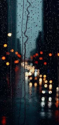 This phone live wallpaper shows a beautiful city view through a rainy window, with glowing street lanterns and a bokeh effect adding a dreamy quality to the backdrop