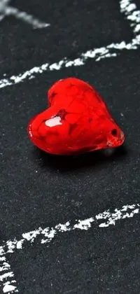 This phone live wallpaper features a stunning red heart with intricate engraving over a chalkboard background