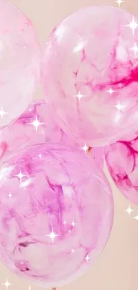 This beautiful phone live wallpaper features a bunch of colorful balloons on a table against a pink cloudy background with a baroque touch