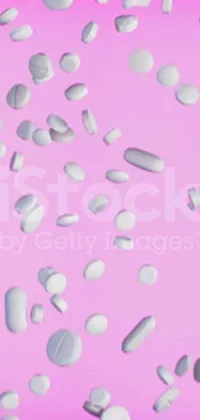 This lively phone wallpaper features a captivating pink background adorned with an array of white pills