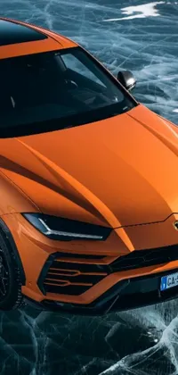 This live phone wallpaper showcases an orange Lamborghini SUV driving through a body of water
