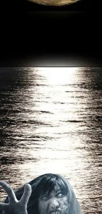 This live wallpaper depicts a beautiful natural scene, featuring a body of water with gentle waves and a full moon in the background
