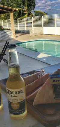 This phone live wallpaper features two bottles of beer sitting next to a crystal-clear pool