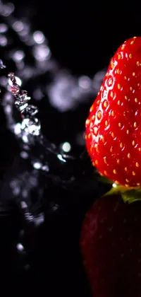 This stunning live wallpaper for your phone boasts a close-up view of a ripe and juicy strawberry against a black background
