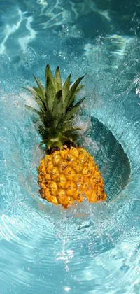 This vibrant live wallpaper features a juicy pineapple floating serenely in a sparkling pool of clear water